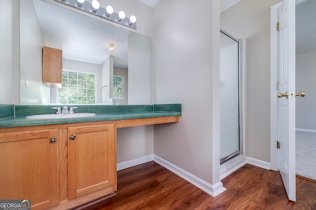 bathroom featuring an enclosed shower, wood-type flooring, a textured ceiling, and vanity