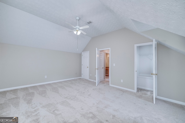 additional living space with ceiling fan, a textured ceiling, lofted ceiling, and light colored carpet