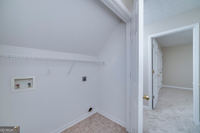 washroom featuring a textured ceiling, electric dryer hookup, hookup for a washing machine, and light carpet