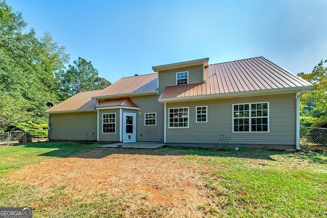 rear view of house featuring a yard