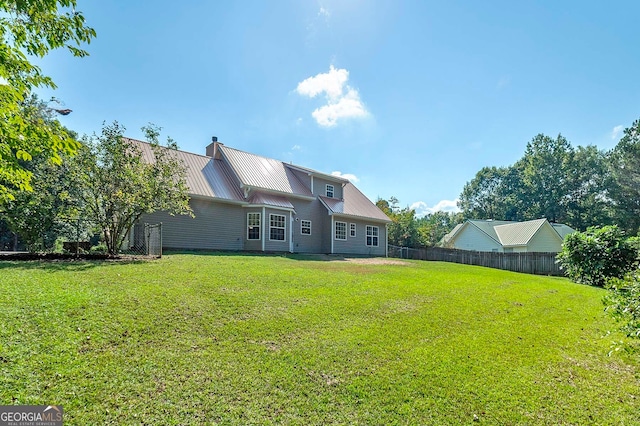 rear view of property with a lawn