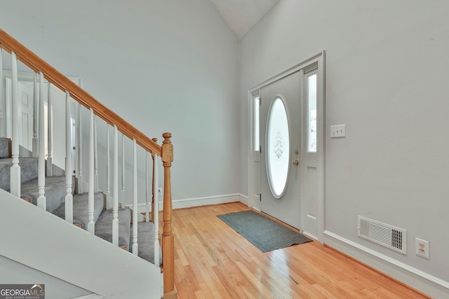 entrance foyer with high vaulted ceiling and wood-type flooring