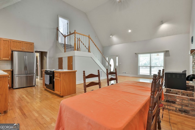 dining space featuring light hardwood / wood-style floors and high vaulted ceiling