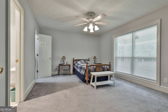 carpeted bedroom with ceiling fan and a textured ceiling