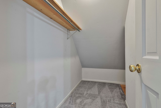 spacious closet with light colored carpet and vaulted ceiling