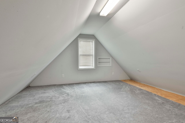 bonus room with light carpet and lofted ceiling