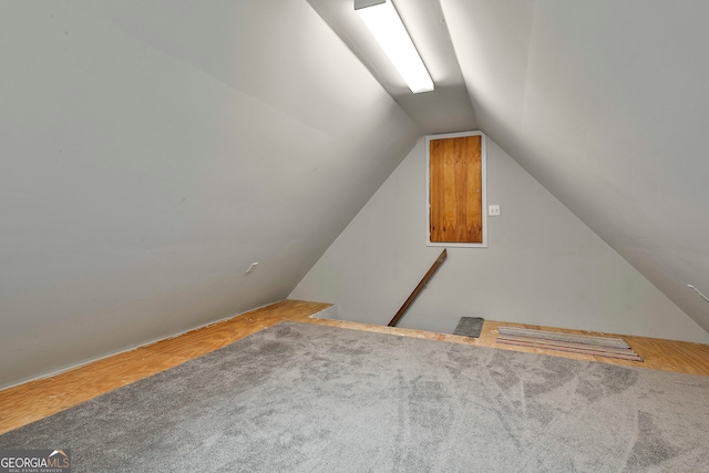 additional living space featuring carpet and lofted ceiling