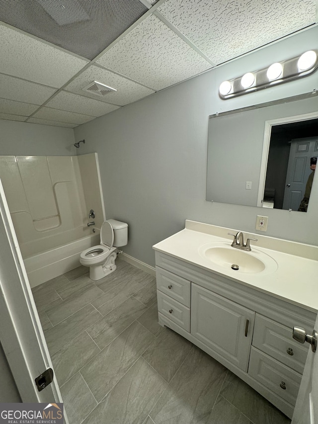 full bathroom featuring tub / shower combination, vanity, toilet, and a paneled ceiling