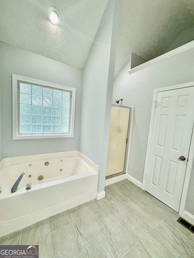 bathroom with shower with separate bathtub, vaulted ceiling, and a textured ceiling