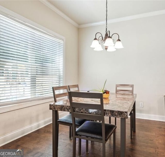 dining area featuring dark hardwood / wood-style flooring, ornamental molding, and an inviting chandelier