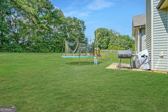 view of yard with a trampoline and a playground