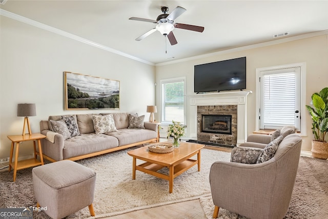 living room featuring crown molding, a fireplace, and ceiling fan