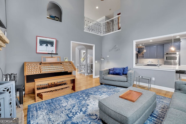 living room with a high ceiling and light wood-type flooring