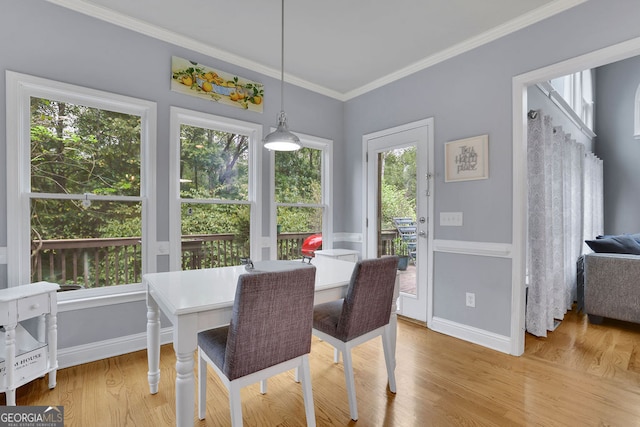 dining area featuring wood-type flooring and ornamental molding