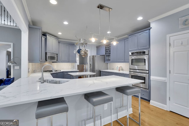 kitchen with sink, a kitchen bar, backsplash, kitchen peninsula, and stainless steel appliances