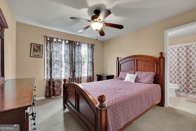 carpeted bedroom with ensuite bathroom and ceiling fan