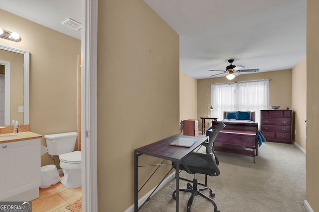 carpeted bedroom with sink and ceiling fan