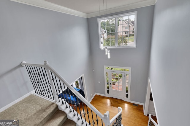 staircase featuring crown molding and hardwood / wood-style flooring