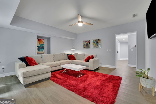 living room featuring hardwood / wood-style flooring and ceiling fan