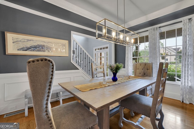 dining space with ornamental molding and hardwood / wood-style floors