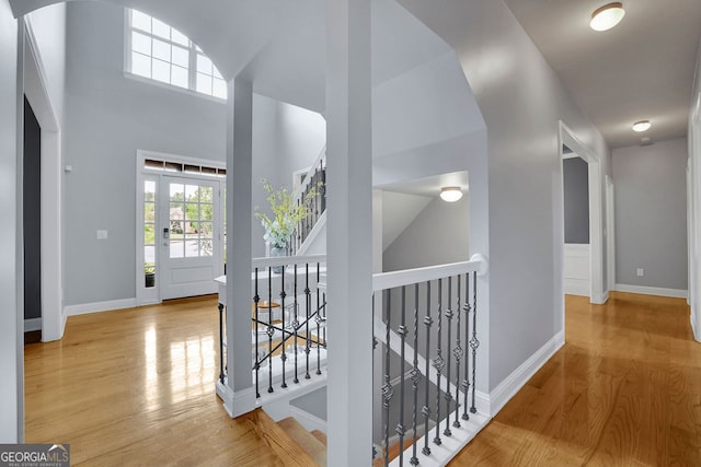 corridor with hardwood / wood-style flooring and a high ceiling