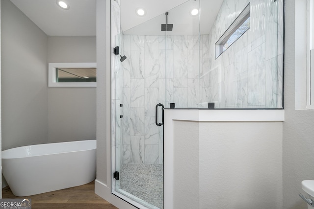 bathroom with wood-type flooring and independent shower and bath