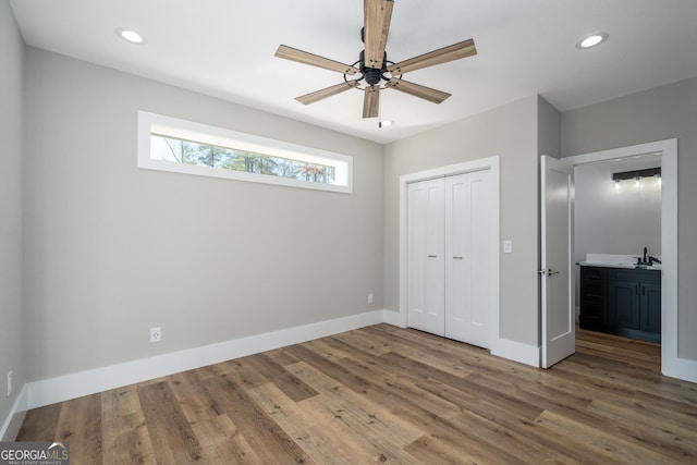 unfurnished bedroom featuring ceiling fan, a closet, and wood-type flooring