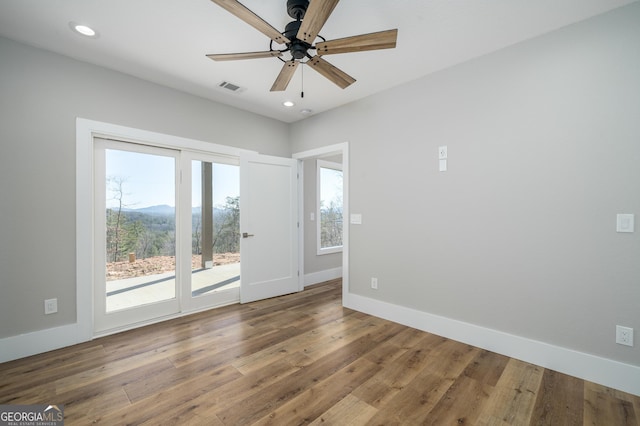 spare room featuring ceiling fan, a mountain view, and hardwood / wood-style flooring