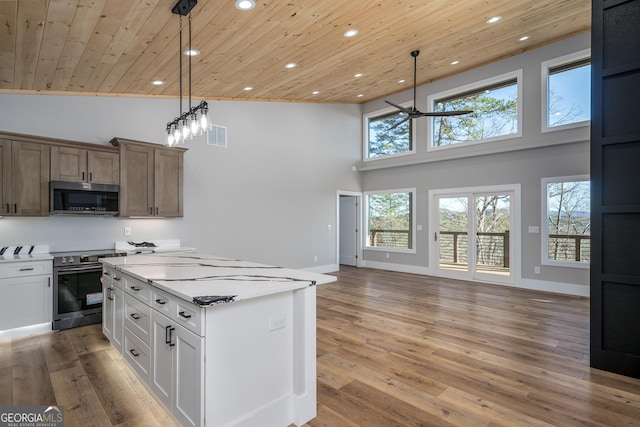 kitchen featuring pendant lighting, ceiling fan, appliances with stainless steel finishes, white cabinetry, and wood ceiling