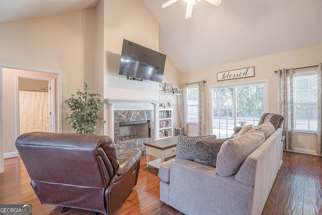 living room featuring ceiling fan, wood-type flooring, a high end fireplace, and high vaulted ceiling