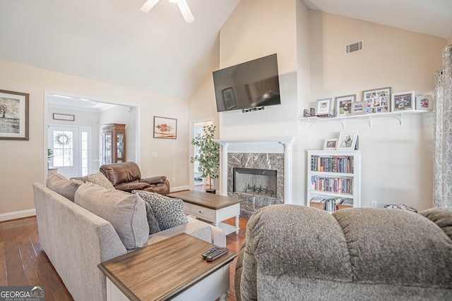 living room with ceiling fan, a premium fireplace, dark wood-type flooring, and high vaulted ceiling