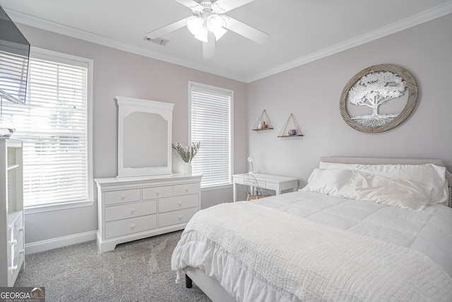 carpeted bedroom featuring multiple windows, ceiling fan, and crown molding