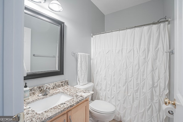 bathroom with vanity, toilet, and curtained shower