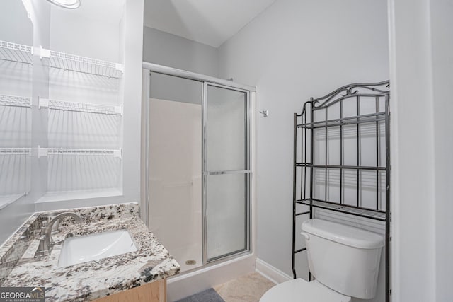 bathroom featuring tile patterned floors, a shower with shower door, vanity, and toilet