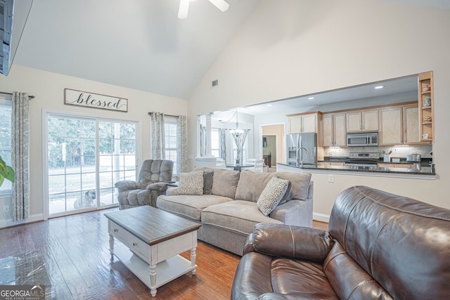 living room featuring ceiling fan, high vaulted ceiling, sink, and hardwood / wood-style flooring