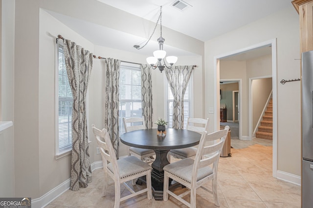 dining space featuring a notable chandelier and light tile patterned floors