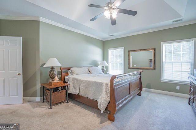 carpeted bedroom with crown molding, ceiling fan, and a raised ceiling