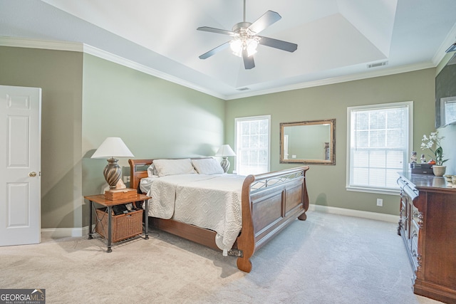 carpeted bedroom featuring ceiling fan, a raised ceiling, and crown molding