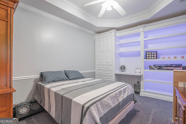 carpeted bedroom with ceiling fan, a raised ceiling, and crown molding