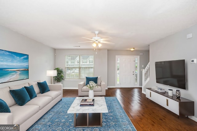 living room with ceiling fan and dark wood-type flooring