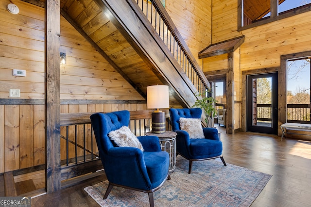 living area featuring high vaulted ceiling, wooden walls, dark hardwood / wood-style floors, and wood ceiling