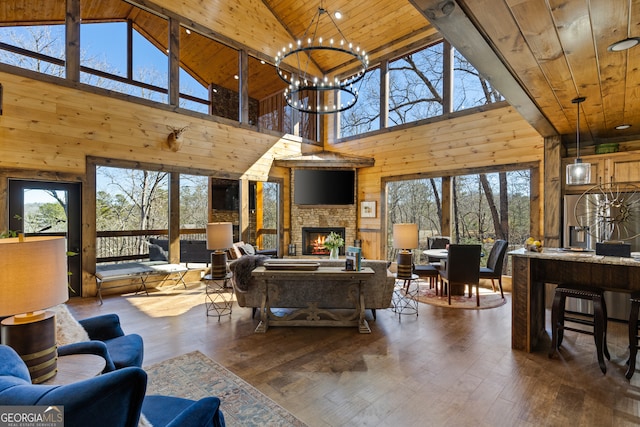 living room featuring a stone fireplace, wood walls, hardwood / wood-style floors, and high vaulted ceiling