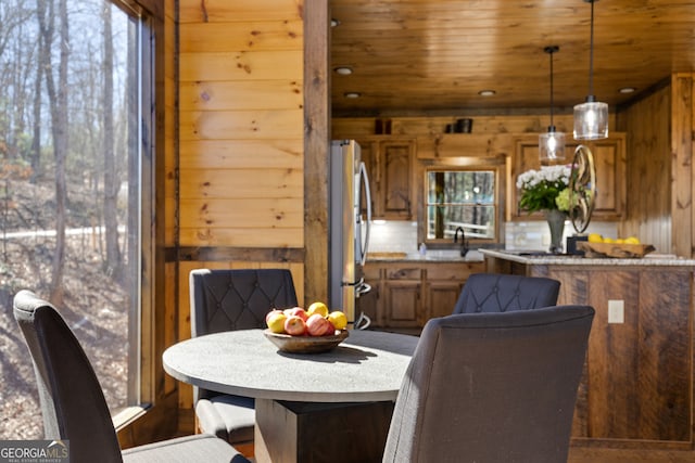 dining space featuring wood walls and wooden ceiling