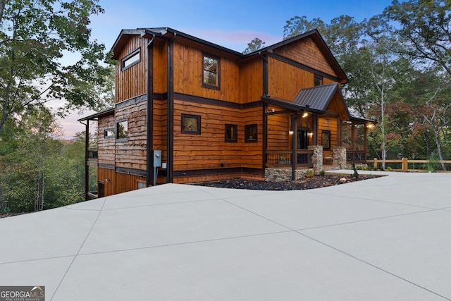 property exterior at dusk featuring covered porch