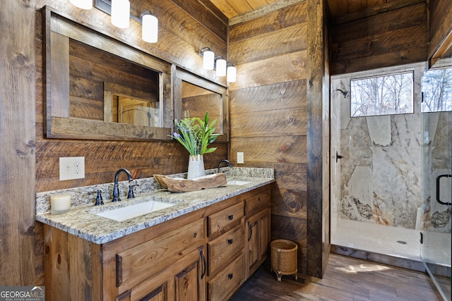 bathroom with wood ceiling, wooden walls, a shower with door, hardwood / wood-style floors, and vanity