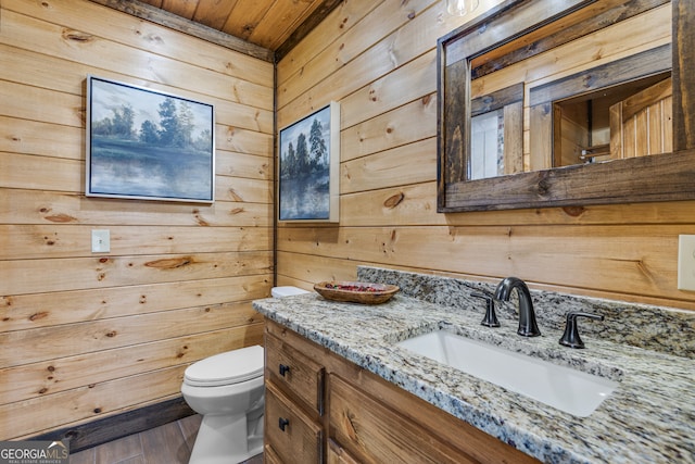 bathroom featuring wood ceiling, wooden walls, hardwood / wood-style floors, vanity, and toilet