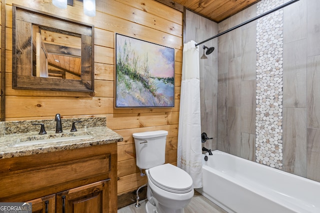 full bathroom featuring wooden walls, vanity, and toilet