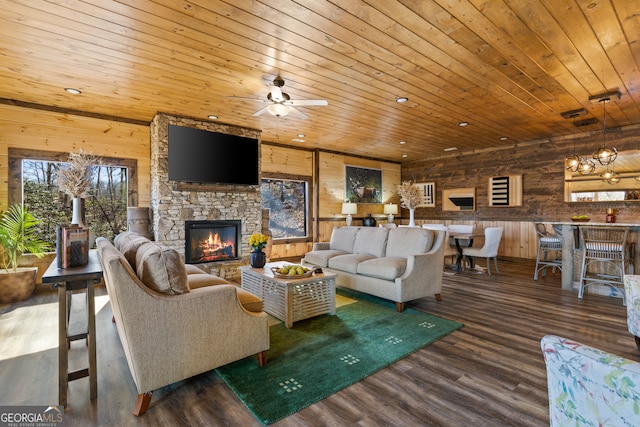 living room featuring wood-type flooring, a stone fireplace, wood ceiling, and wood walls