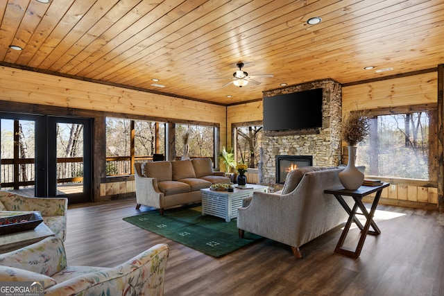 living room featuring wooden ceiling, wood-type flooring, wooden walls, and a wealth of natural light