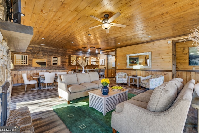 living room featuring wood ceiling, wood-type flooring, ceiling fan, and wooden walls